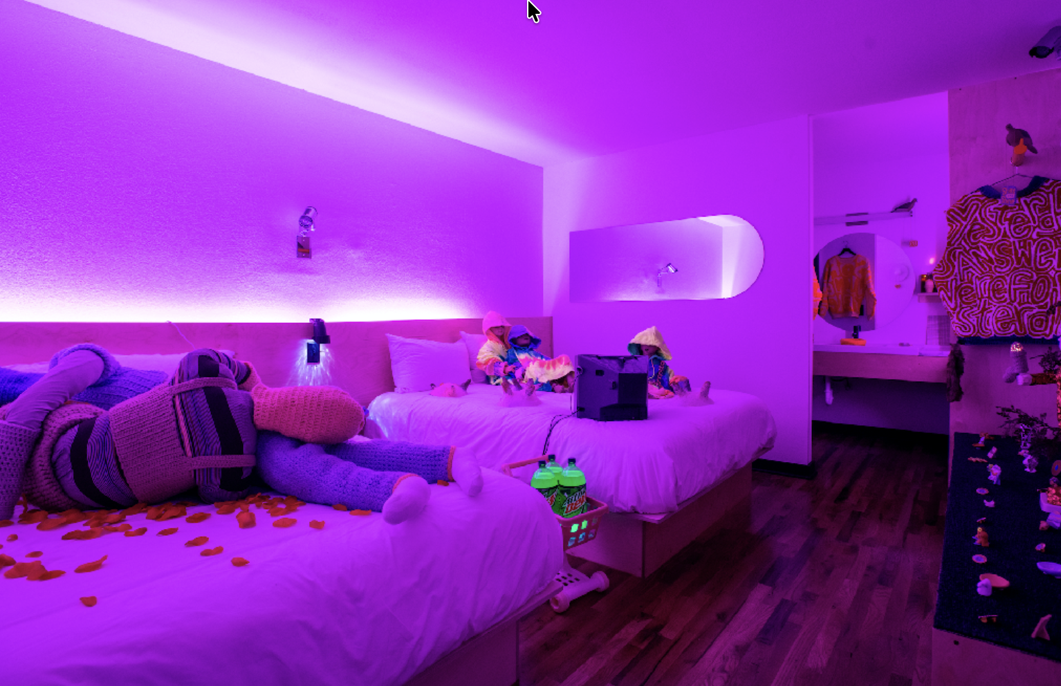 Purple-lit event room with custom bedding, props, and installation details
