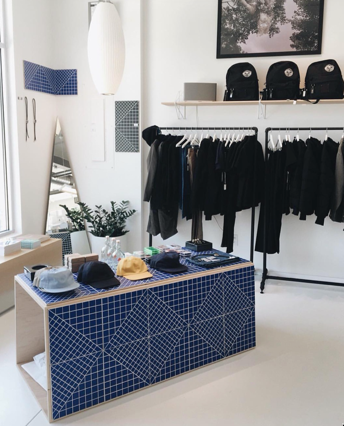 Retail environment with blue geometric display table and black apparel